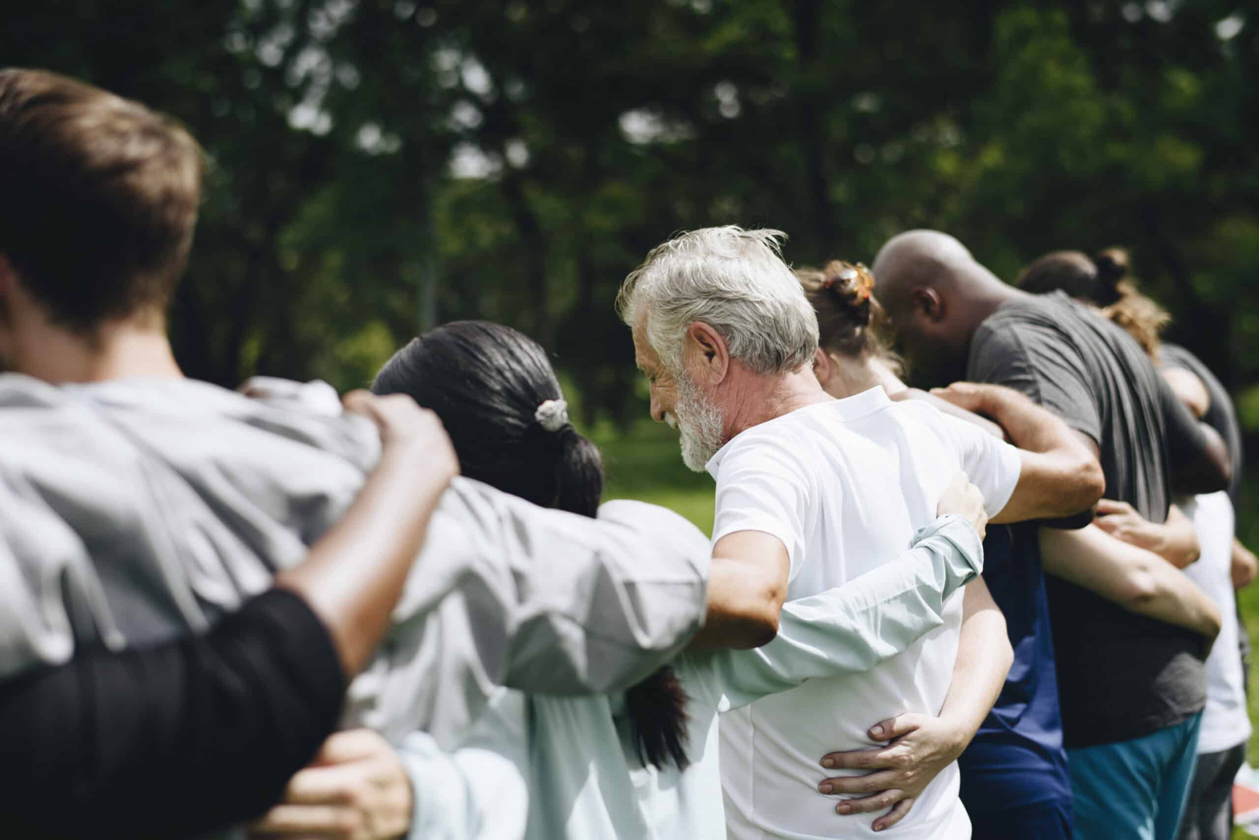 Adults with arms around each other at a park from the back