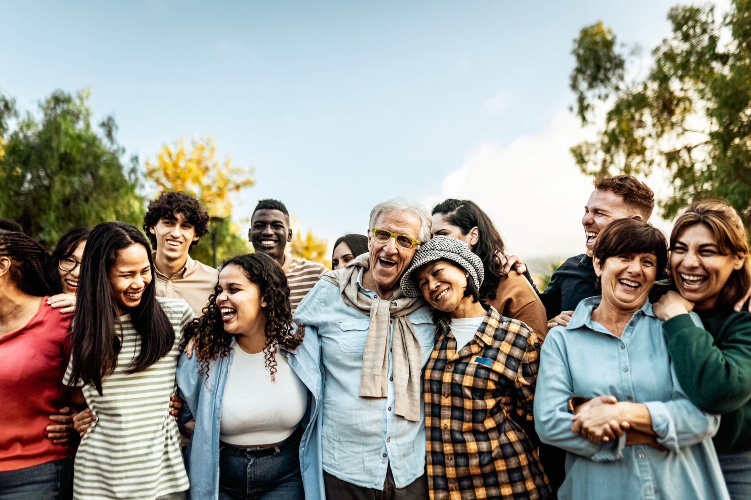 Happy multigenerational people having fun together in a public par