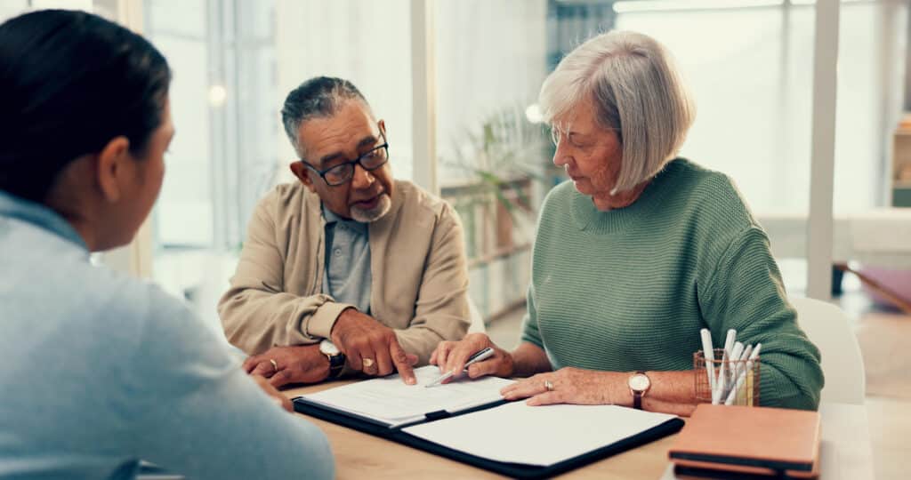 Professional working with elderly couple on legal document