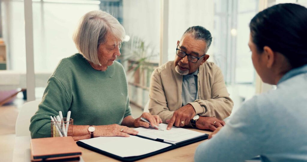 Professional working with elderly couple on legal document